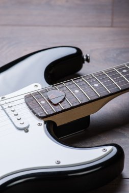 Elektro gitar ile arabulucu bir kahverengi ahşap zemin üzerinde