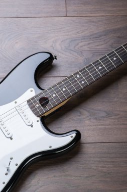 Elektro gitar ile arabulucu bir kahverengi ahşap zemin üzerinde