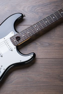 Elektro gitar ile arabulucu bir kahverengi ahşap zemin üzerinde