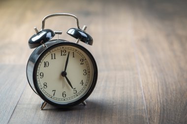 Bir ahşap zemin üzerinde siyah vintage çalar saat