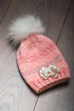 Ahşap yüzey üzerinde pembe ve yeşil örgü şapkalar