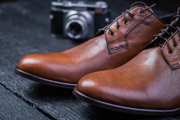 Zapatos de cuero marrón en piso negro — Foto de Stock