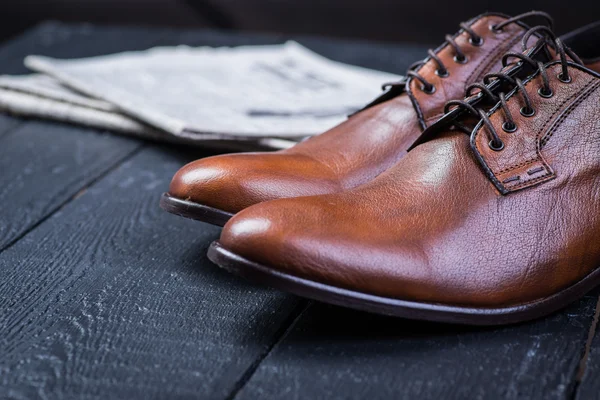 Brown leather shoes on black floor — Stock Photo, Image