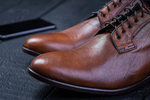 Brown leather shoes on black floor — Stock Photo, Image