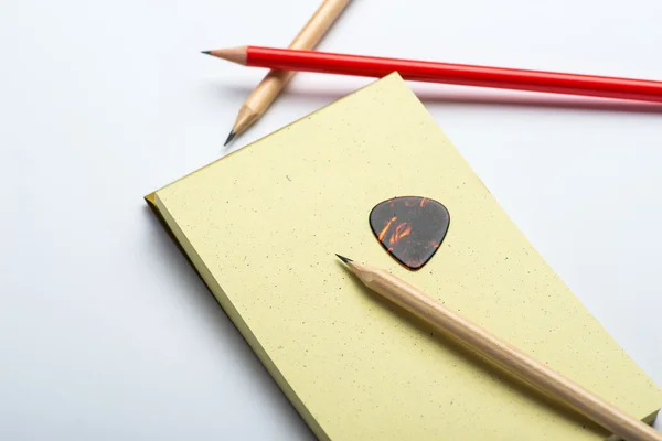 Yellow notepad with two pencils and mediator on white surface — Stock Photo, Image