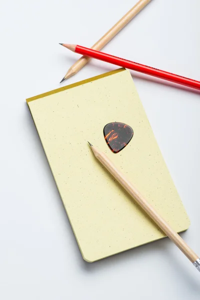 Yellow notepad with two pencils and mediator on white surface — Stock Photo, Image