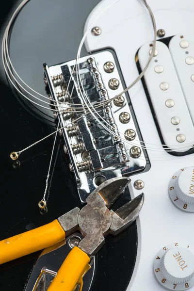 Electric guitar with yellow nippers and strings — Stock Photo, Image