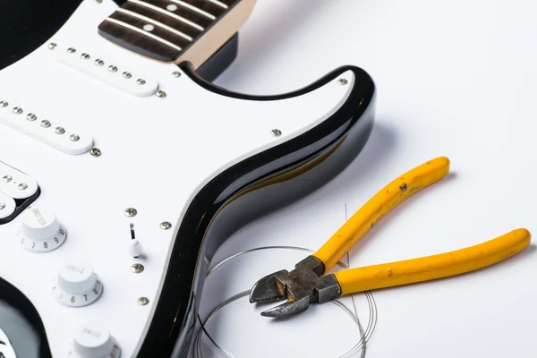 Electric guitar with yellow nippers and strings — Stock Photo, Image