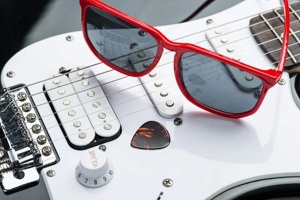 Electric guitar with red sunglasses and mediator — Stock Photo, Image