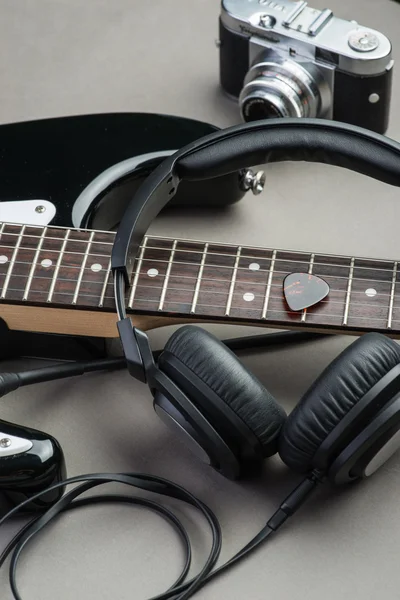 Electric guitar with headphones and camera on a brown wooden floor — Stock Photo, Image