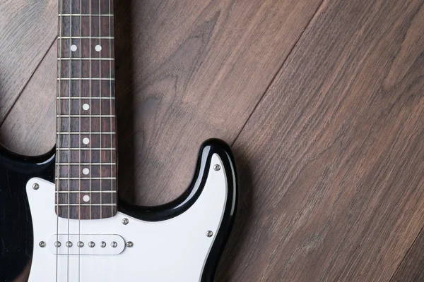 Electric guitar on a brown wooden floor — Stock Photo, Image