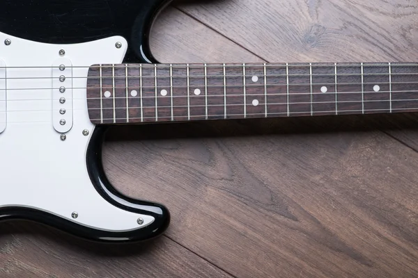 Electric guitar on a brown wooden floor — Stock Photo, Image