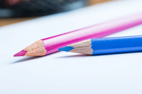 Lápices rosas y azules con una hoja de papel blanco —  Fotos de Stock