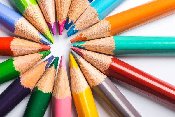 Varios lápices de color en una hoja de papel blanco — Foto de Stock