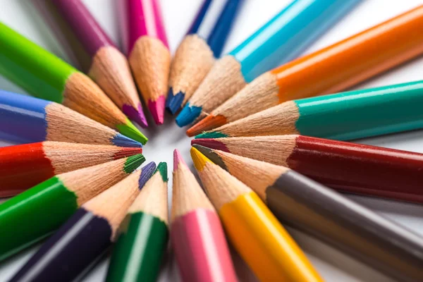 Varios lápices de color en una hoja de papel blanco — Foto de Stock