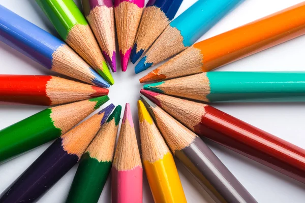Varios lápices de color en una hoja de papel blanco — Foto de Stock