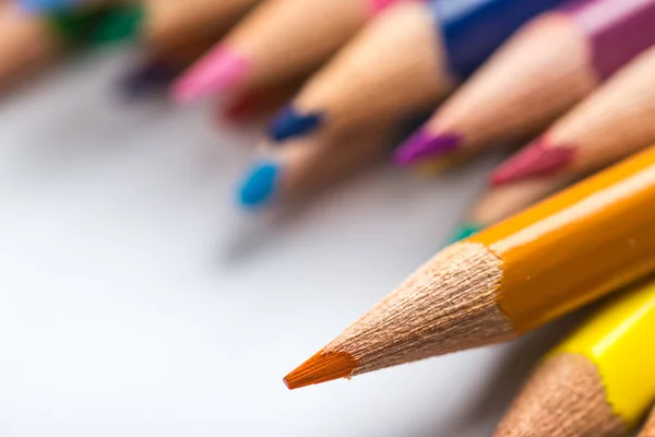 Varios lápices de color en una hoja de papel blanco — Foto de Stock