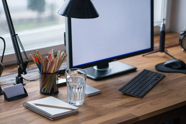 Lichte en gezellige werkplek met glas water — Stockfoto