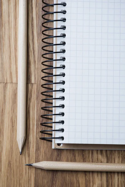 Cuaderno y lápiz sobre una mesa de madera — Foto de Stock