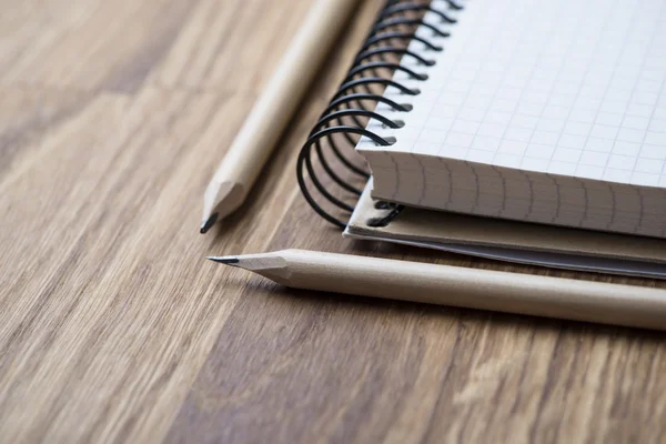 Caderno e lápis em uma mesa de madeira — Fotografia de Stock