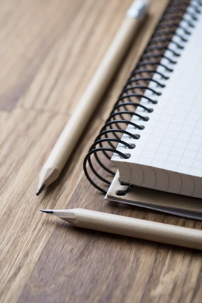 Caderno e lápis em uma mesa de madeira — Fotografia de Stock