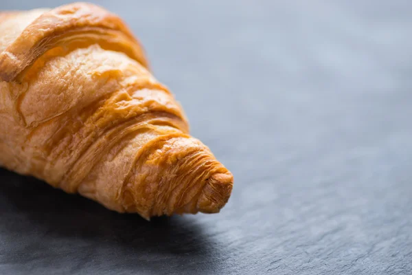 Chutné francouzským croissantem na černou kamennou desku — Stock fotografie