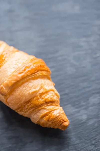 Chutné francouzským croissantem na černou kamennou desku — Stock fotografie