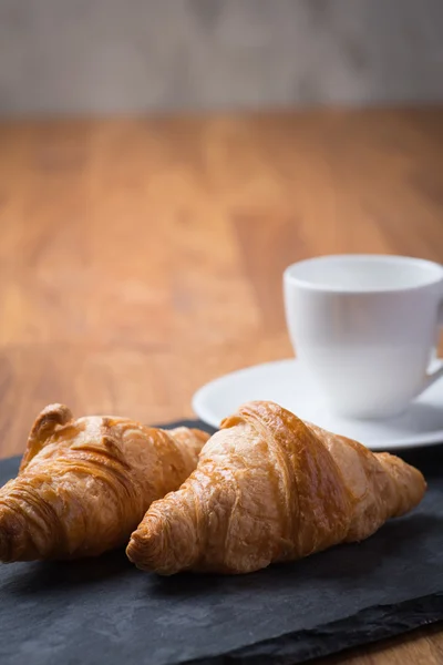 Dvě chutné francouzské croissanty s šálkem kávy — Stock fotografie