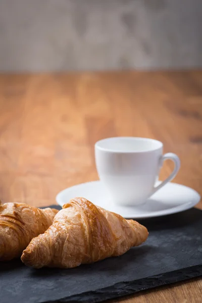 Dvě chutné francouzské croissanty s šálkem kávy — Stock fotografie