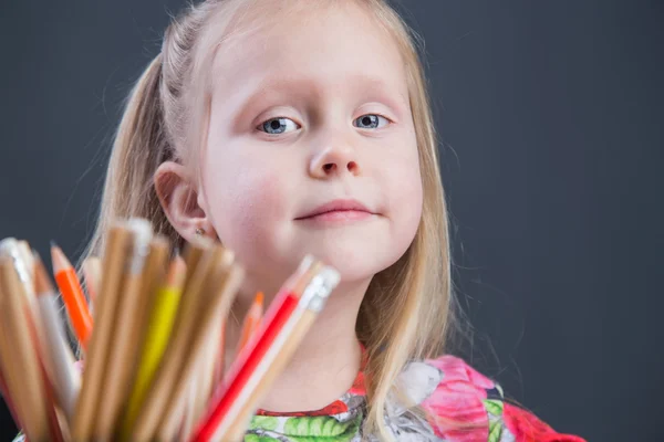 Kleine meisje afbeeldingen tekenen met potloden — Stockfoto