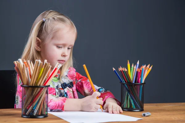 Pieni nuori tyttö piirustus kuvia kyniä — kuvapankkivalokuva