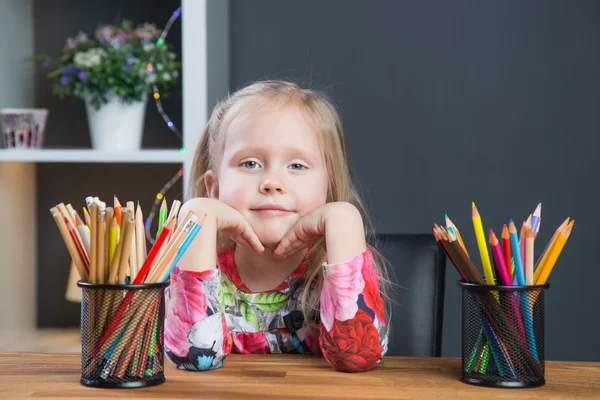 Маленька молода дівчинка малює картини з кольоровими олівцями — стокове фото