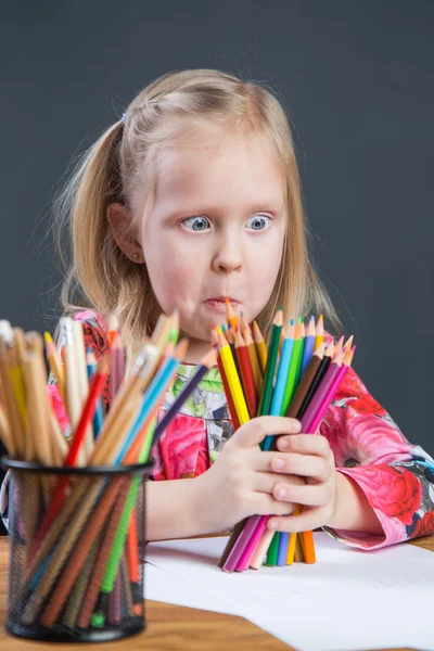 Small young girl drawing pictures with color pencils — Stock Photo, Image