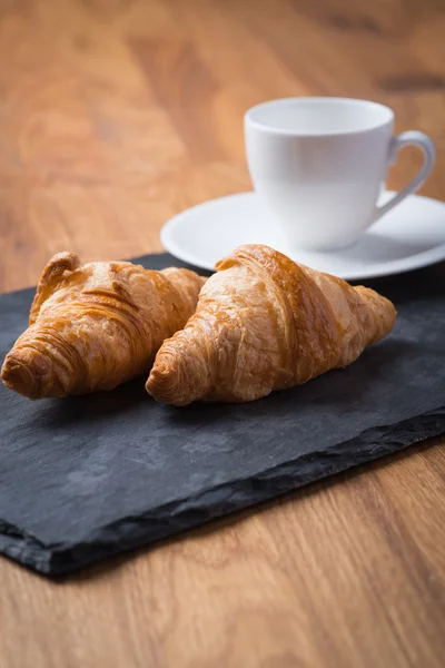 Dvě chutné francouzské croissanty s šálkem kávy Stock Obrázky