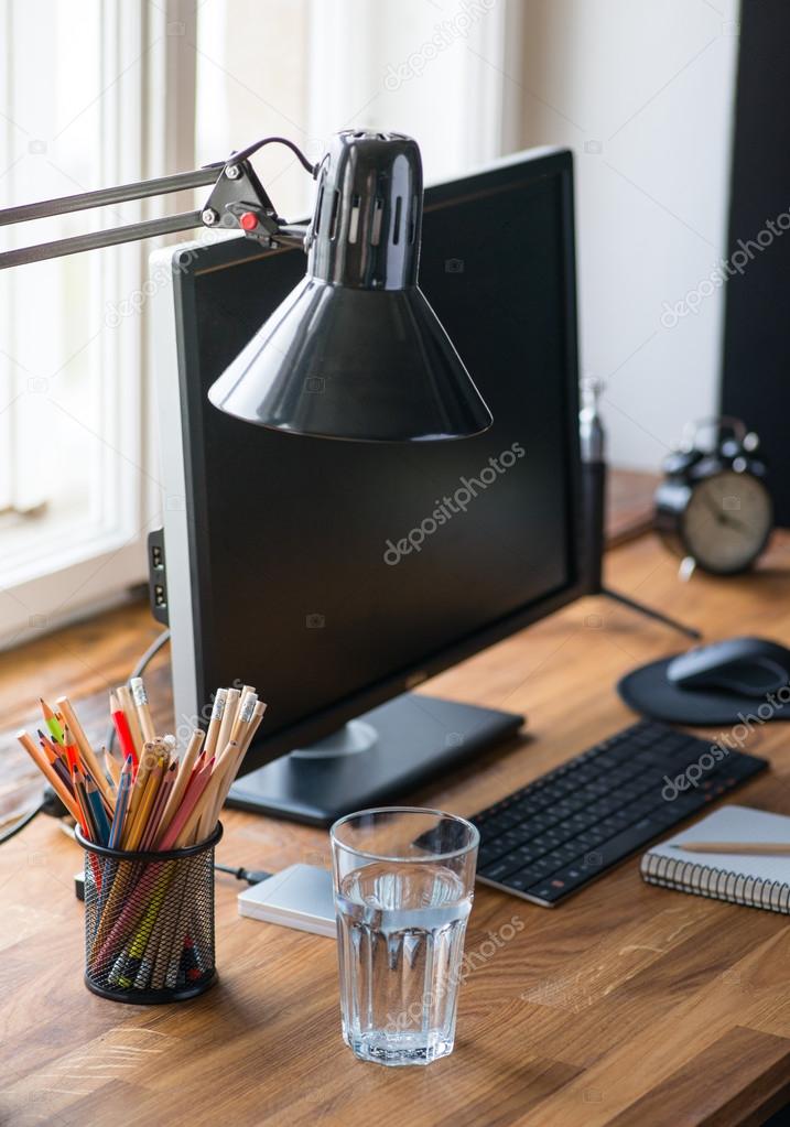 Light and cozy workplace with glass of water