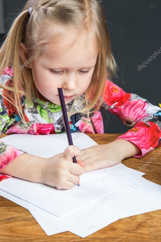 Small young girl drawing pictures with pencils