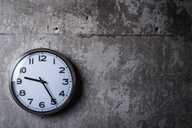 Gri beton duvara asılı yuvarlak duvar saati