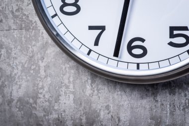 Gri beton duvara asılı yuvarlak duvar saati