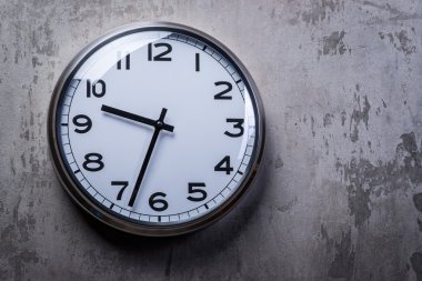 Gri beton duvara asılı yuvarlak duvar saati