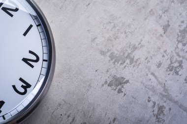 Gri beton duvara asılı yuvarlak duvar saati