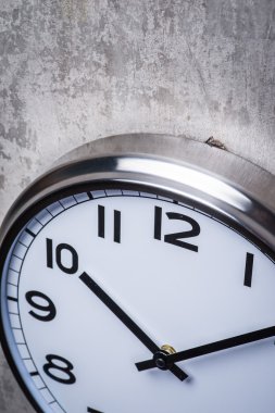 Gri beton duvara asılı yuvarlak duvar saati