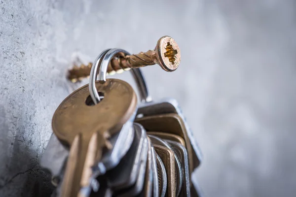 Ein Bündel alter verschlissener Schlüssel an der grauen Betonwand — Stockfoto