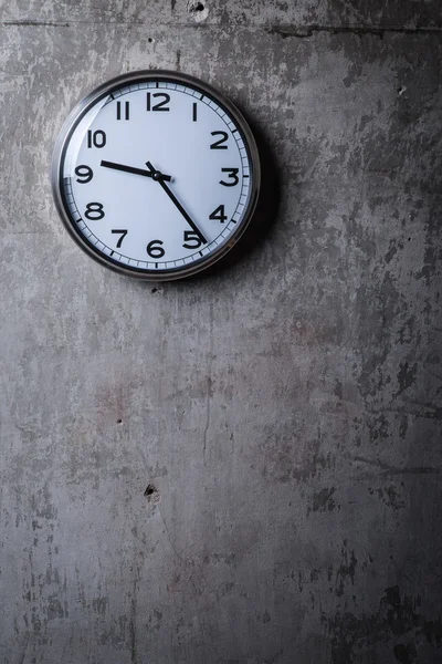 Runde Wanduhr hängt an der grauen Betonwand — Stockfoto