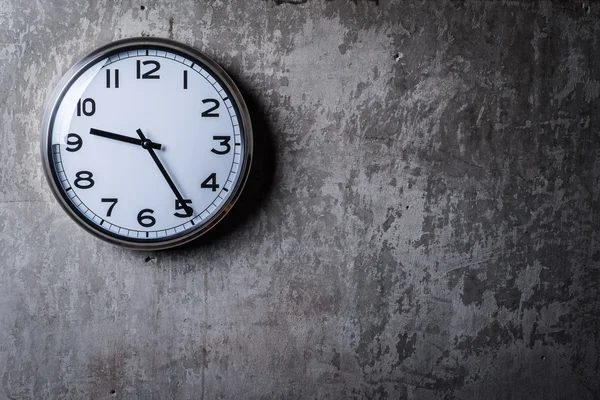 Runde Wanduhr hängt an der grauen Betonwand — Stockfoto