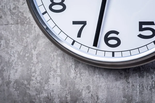 Gri beton duvara asılı yuvarlak duvar saati