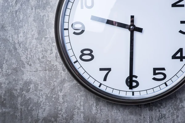 Gri beton duvara asılı yuvarlak duvar saati