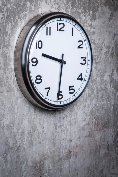 Round wall clock hanging on the grey concrete wall — Stock Photo, Image