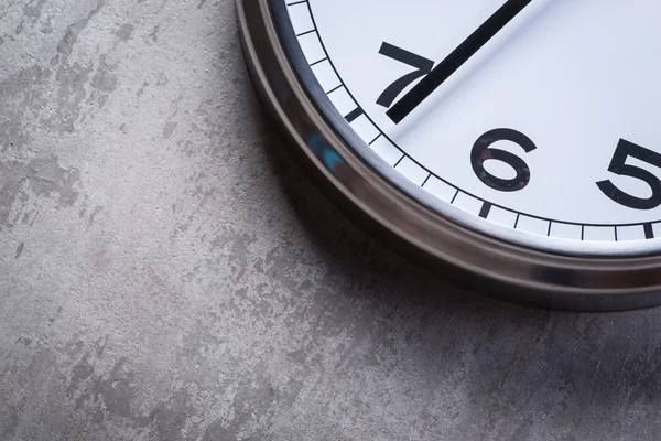 Gri beton duvara asılı yuvarlak duvar saati