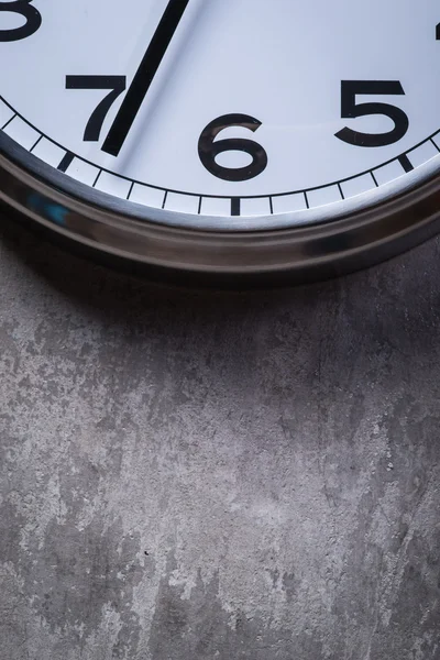 Круглые часы, висящие на серой бетонной стене — стоковое фото