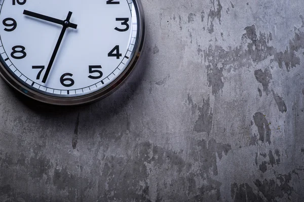 Runde Wanduhr hängt an der grauen Betonwand — Stockfoto